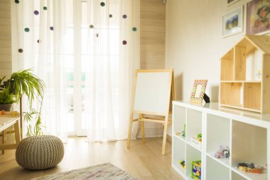 Taburesi ve resim masası olan anaokulu odası. Çocuk odası ve mobilya 