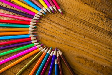 ahşap masanın üzerinde yatan renkli kalemler 