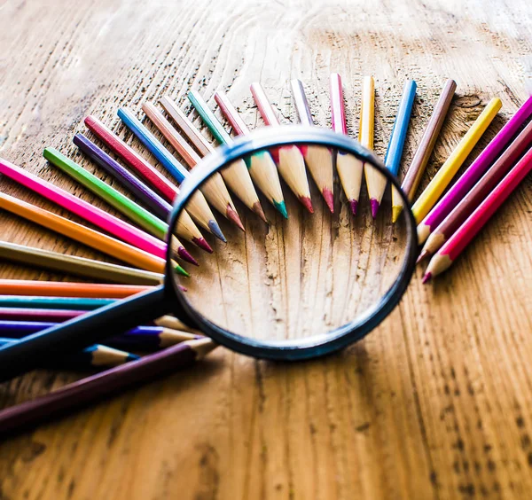 Pencils under magnifying glass — Stock Photo, Image