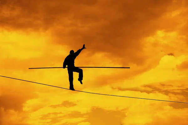 businessman with pole on rope.