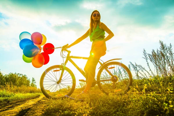 Young Girl in sexy dress  riding bicycle flying air balloons