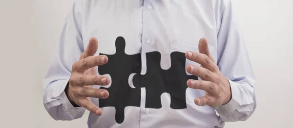 Businessman with two pieces of puzzle — Stock Photo, Image