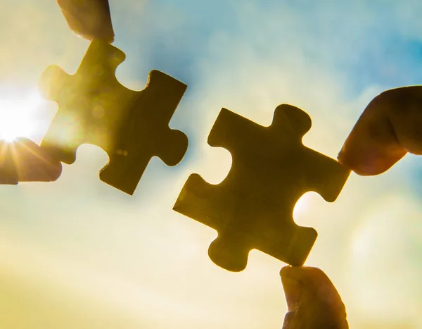 Hands trying to connect  puzzle pieces — Stock Photo, Image