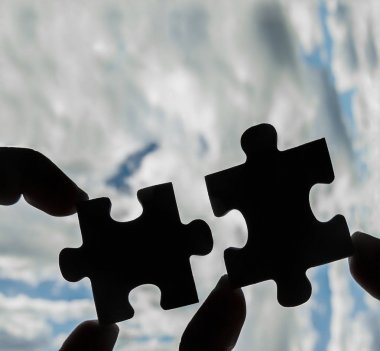 puzzle parçaları bağlanmaya çalışan eller 