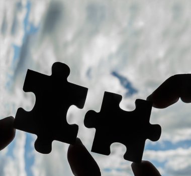 puzzle parçaları bağlanmaya çalışan eller 
