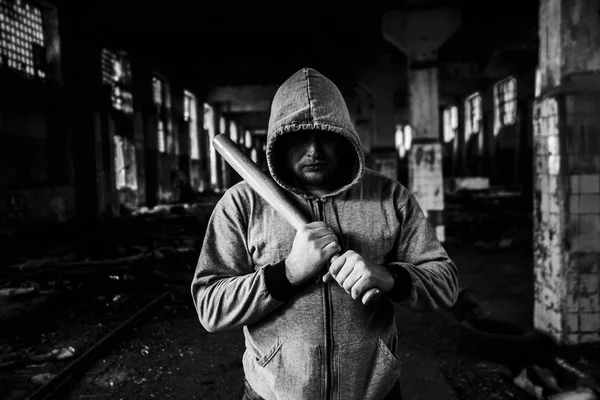 Aggressive man with a baseball bat wearing  hoody