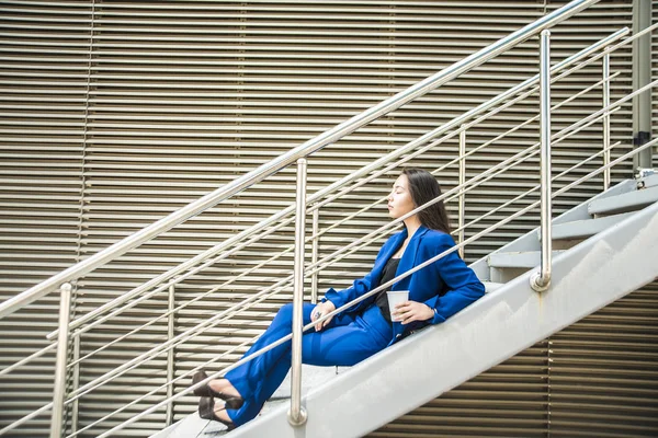 Femme d'affaires dans les escaliers se reposant — Photo