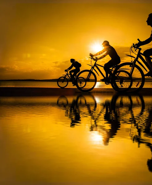 Boşluk Gün Batımında Bisiklete Binen Sportif Arkadaşlar Bisikletçiler Sahil Boyunca — Stok fotoğraf
