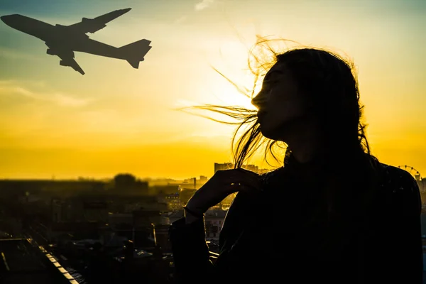 Vrouw tegen vliegen vliegtuig — Stockfoto