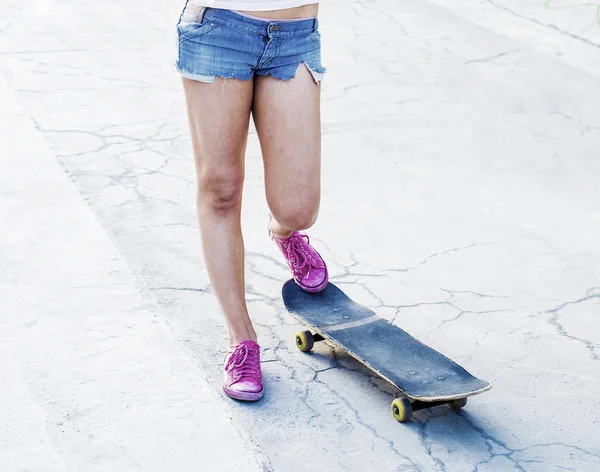 Teen girl standing on skateboard — Stock Photo, Image