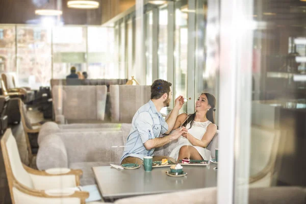 Man feeding a biscuit to his girlfriend — Stock Photo, Image