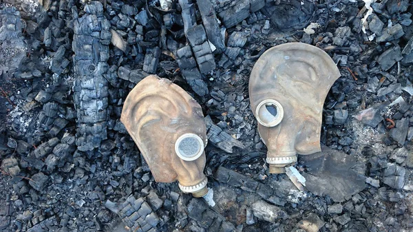 Yangın - yanık ahşap ev veya bina iki gaz maskesi. bir kaç kırık gözlük ile gasmasks. felaket, felaket arka plan