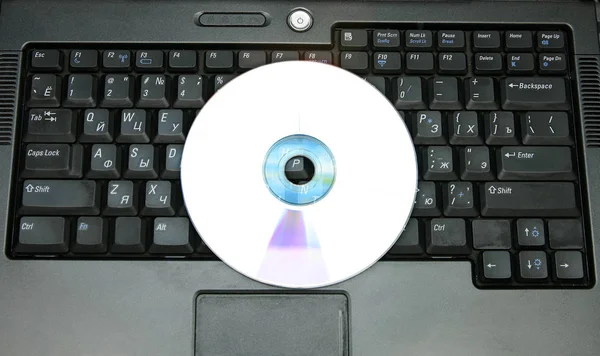 Compact disc  on black keyboard — Stock Photo, Image