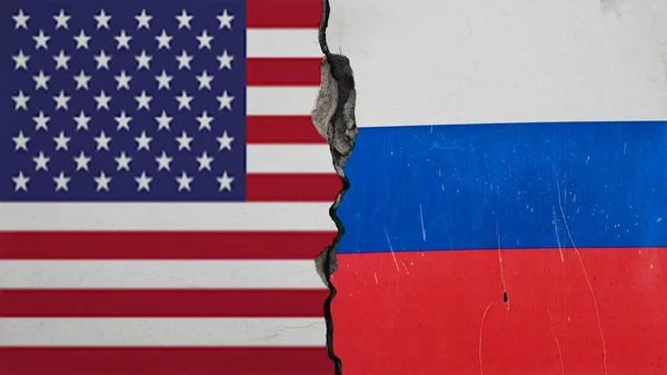 垂直开裂的水泥白色或灰墙背景 混凝土墙体结构裂缝的背景 两块美国 俄罗斯国旗在纹理破获墙 — 图库照片