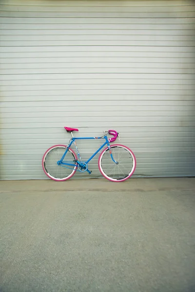 Bicicleta contra parede de metal cinza — Fotografia de Stock