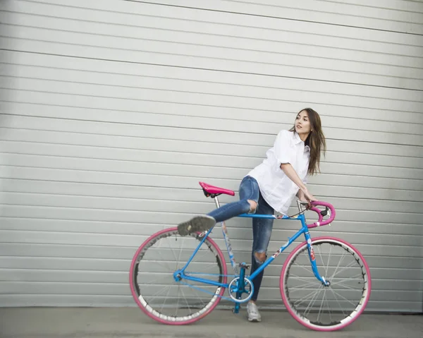 Женщина с голубым велосипедом — стоковое фото