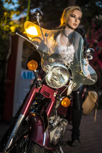 专注于车灯 复古摩托车 一个很酷的女人在老式摩托车骑自行车的女孩 — 图库照片