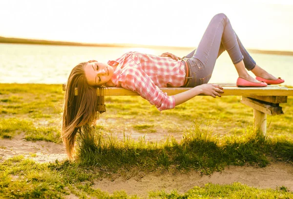 Femme couchée sur le banc — Photo