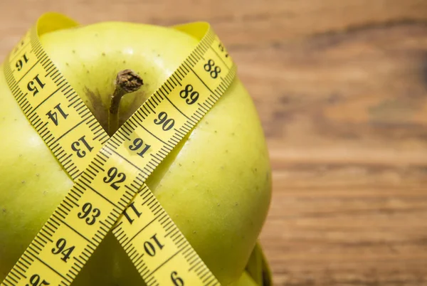 Meetlint gewikkeld rond een groene appel — Stockfoto