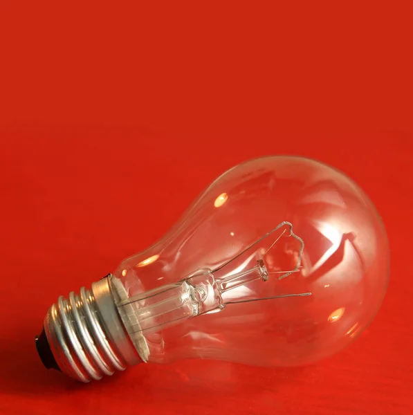 Bulb on red texture background. — Stock Photo, Image