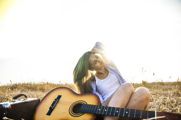 Meisje zit in de buurt van gitaar — Stockfoto