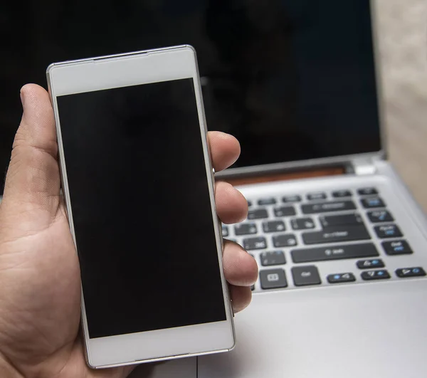 Mann benutzt Handy und Laptop — Stockfoto