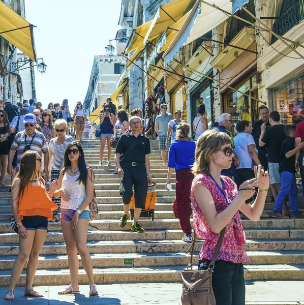 İtalya, VENICE - 19 Haziran 2014 Venedik 'teki kalabalık yaya geçidi. Bir sürü yaya, sahil yolunda yürümeye devam ediyor. Taraflarda tarihi merdivenlere karşı birkaç dükkan var.