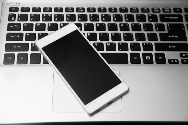 Laptop en de telefoon op de tafel. — Stockfoto