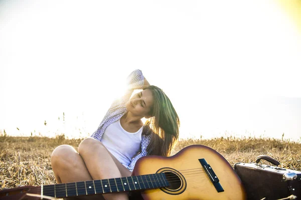 Chica sentada cerca de guitarra —  Fotos de Stock