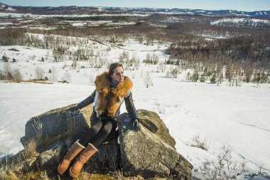 fox zencefil kürk yaka poz ile siyah montlu genç kadın. kış sezonu ve dağ manzara .