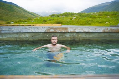 yakışıklı adam ahşap Havuzu. adam doğal mavi su havuzu içinde 