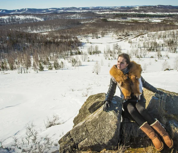 fox zencefil kürk yaka poz ile siyah montlu genç kadın. kış sezonu ve dağ manzara .