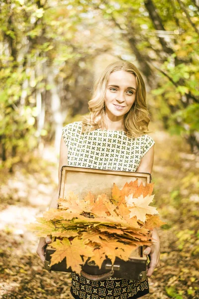 Mulher segurando caso com folhas — Fotografia de Stock