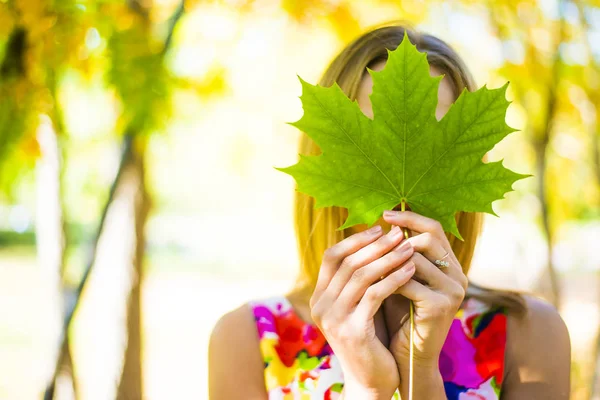 Akçaağaç yaprağı elinde tutan kız
