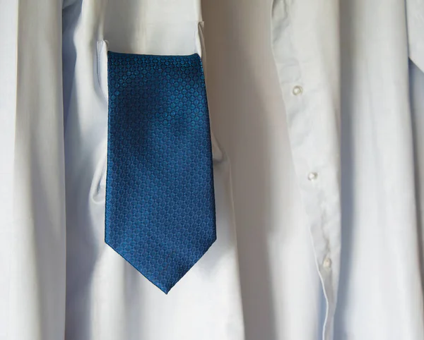 white  shirt with blue neck tie
