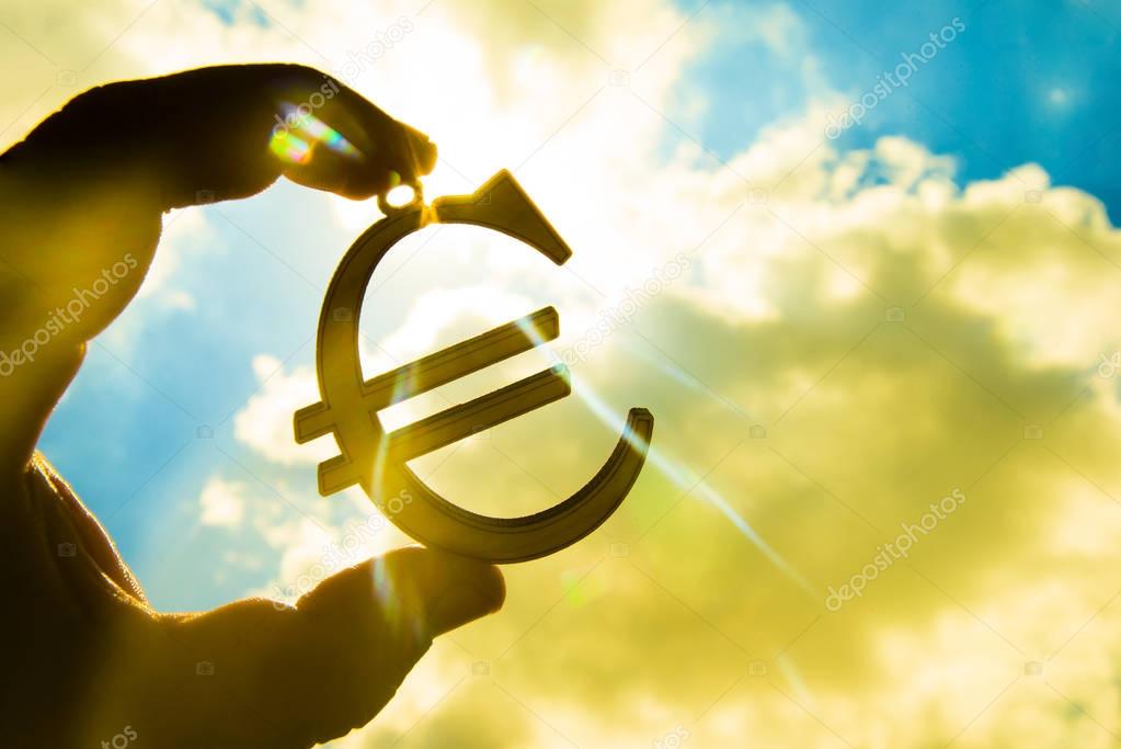 man's hand holding  Euro icon 