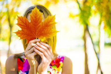 Akçaağaç yaprağı elinde tutan kız