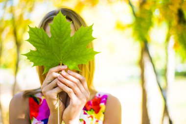 Akçaağaç yaprağı elinde tutan kız