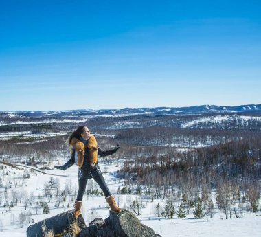 fox zencefil kürk yaka poz ile siyah montlu genç kadın. kış sezonu ve dağ manzara .