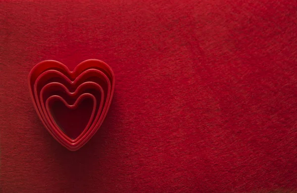 Сердца, формы на красной текстуре — стоковое фото