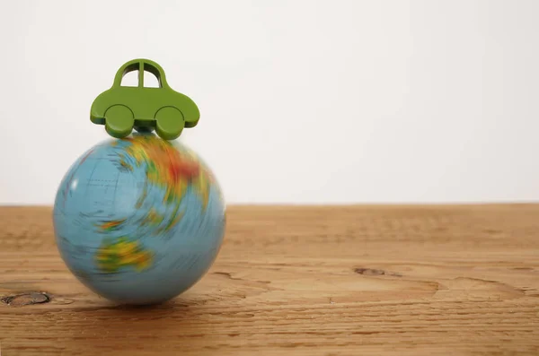 Brinquedo carro verde no globo — Fotografia de Stock