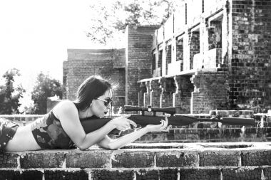 bir keskin nişancı tüfeği olan kadın 