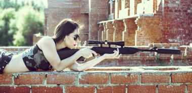 bir keskin nişancı tüfeği olan kadın 