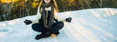 poz lotus. yüz yok. kış parkında oturan kadın