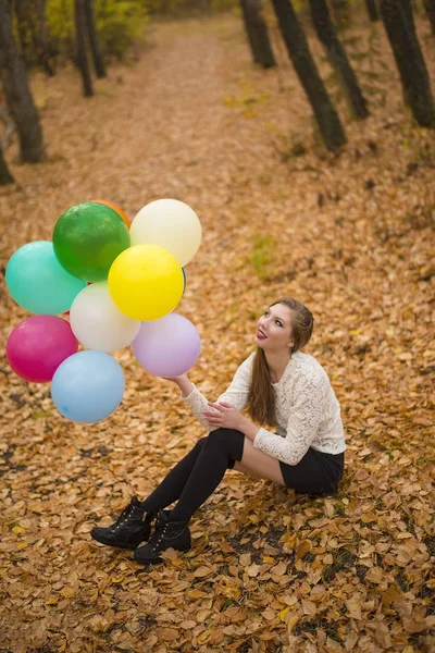 Ormanda elinde renkli balonlar tutan güzel esmer kız 