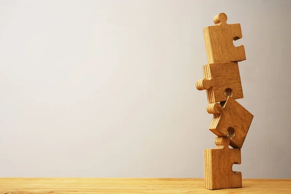 Stukjes van de puzzel op houten tafel — Stockfoto