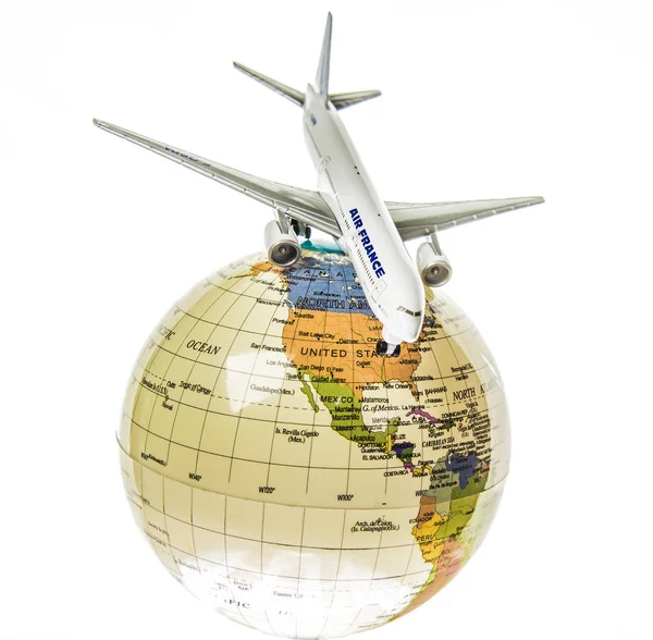Airplane toy flying around the globe — Stock Photo, Image