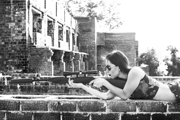 bir keskin nişancı tüfeği olan kadın 