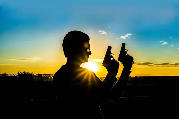 Silhouet Van Een Soldaat Bezit Van Wapens Tegen Industriële Achtergrond — Stockfoto