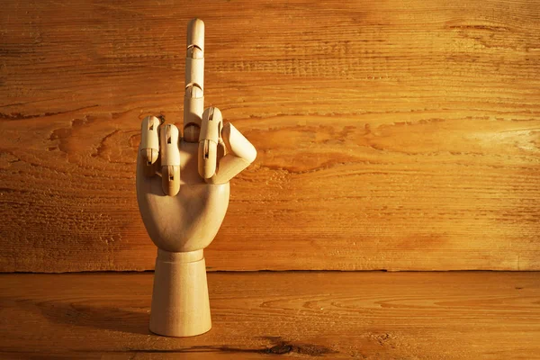 wooden hand showing  middle finger